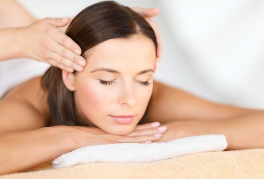 health, beauty, resort and relaxation concept - beautiful woman in spa salon getting face treatment