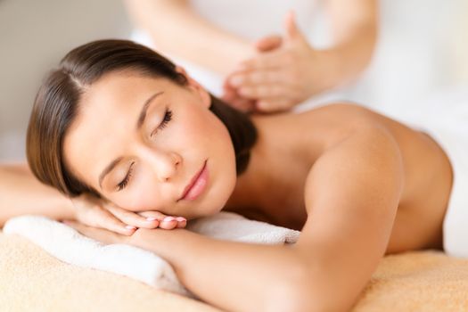 health, beauty, resort and relaxation concept - beautiful woman with closed eyes in spa salon getting massage