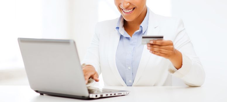 business, banking, technology, money, shopping concept - smiling businesswoman with laptop and credit card