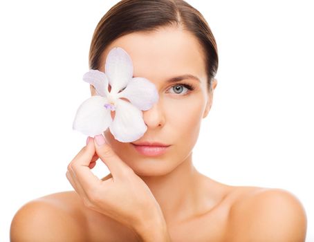 health and beauty concept - relaxed woman with orchid flower over eye