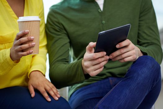 education, technology, people and internet concept - close up of students with tablet pc computer and coffee cup at school