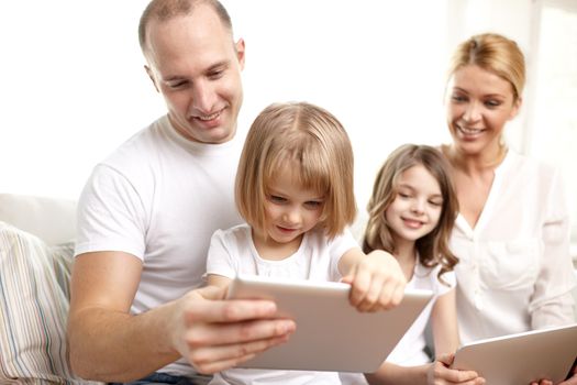 family, technology and people - happy parents and children with tablet pc computers sitting on couch at home