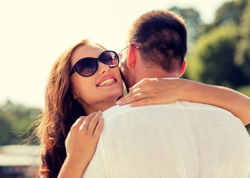 love, wedding, summer, dating and people concept - smiling couple wearing sunglasses hugging in park