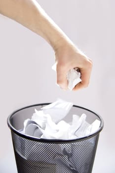 Garbage conceptual image. Man throws paper into a full garbage.
