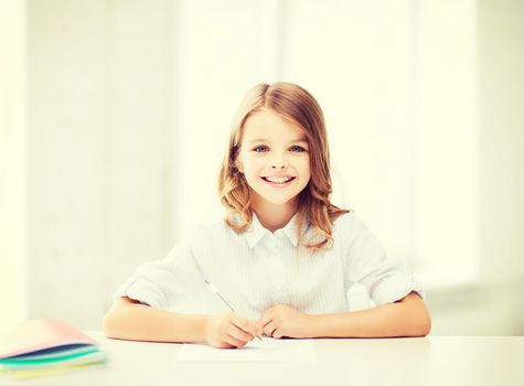 education and school concept - little student girl studying at school