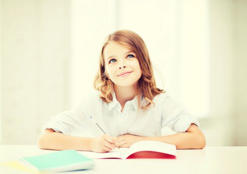 education and school concept - little student girl studying at school