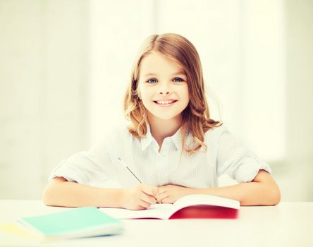 education and school concept - little student girl studying at school