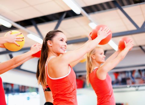 fitness, sport, training, gym and lifestyle concept - group of smiling people working out with stability balls in the gym