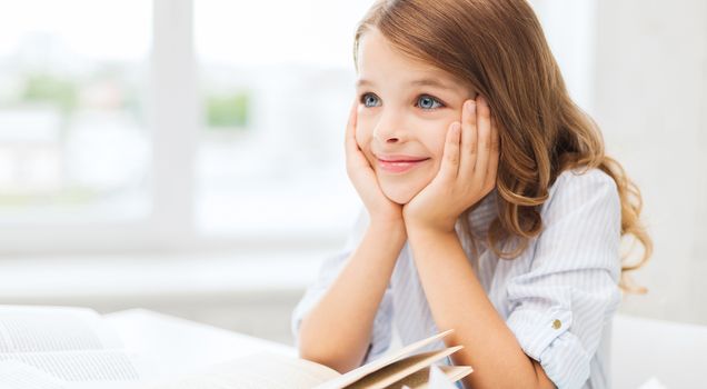 education and school concept - little student girl writing in notebook at school