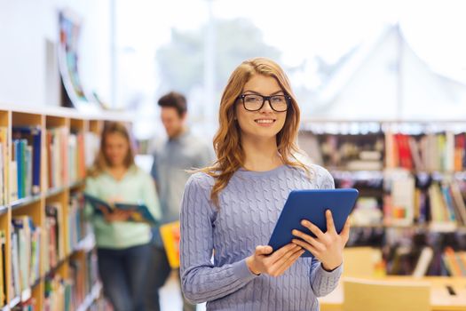 people, education, technology and school concept - happy student girl or woman with tablet pc computer in library