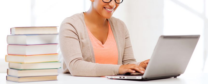 education concept - smiling international student girl with laptop at school