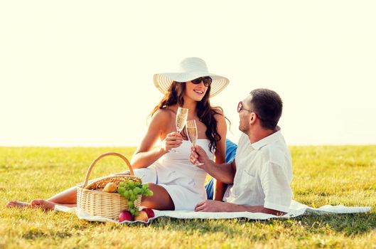 love, dating, people and holidays concept - smiling couple drinking champagne on picnic