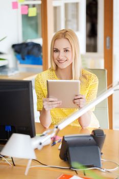 business, startup and people concept - happy businesswoman or creative female office worker with tablet pc computer sitting at table