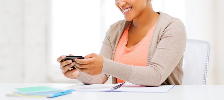business, and communication concept - smiling african woman with smartphone in office