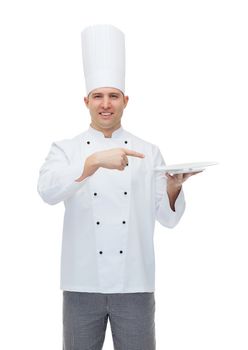 cooking, profession, advertisement and people concept - happy male chef cook showing something on empty plate