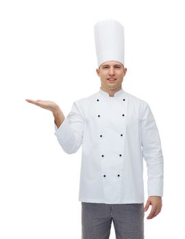 cooking, profession, advertisement and people concept - happy male chef cook showing something on empty palm