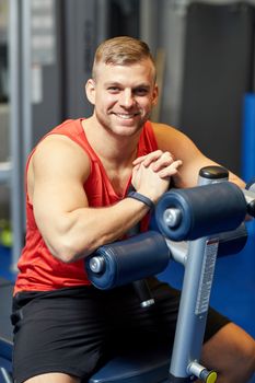 sport, fitness, lifestyle and people concept - smiling man sitting on exercise bench in gym