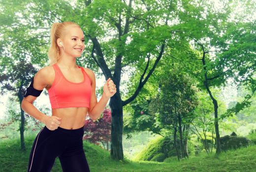 sport, exercise, technology, internet and healthcare - smiling sporty woman running and listening to music from smartphone