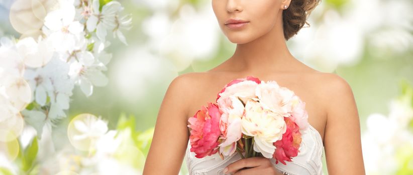 wedding, holidays, people and celebration concept- bride or woman with bouquet of flowers over summer garden and cherry blossom background