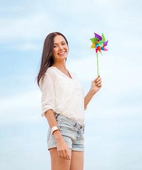 summer holidays, vacation and ecology - girl with windmill toy on the beach