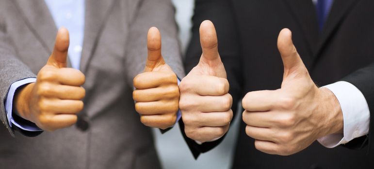 business and office concept - businessman and businesswoman showing thumbs up in office