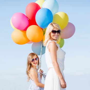 summer holidays, celebration, family, children and people concept - mother and child with colorful balloons