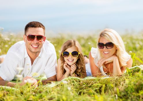 summer holidays, children and people concept - happy family with blue sky and green grass