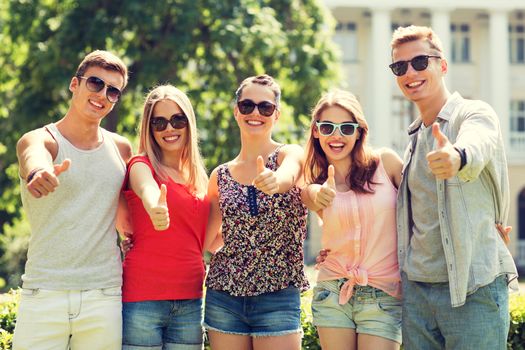 friendship, leisure, summer, gesture and people concept - group of smiling friends showing thumbs up outdoors