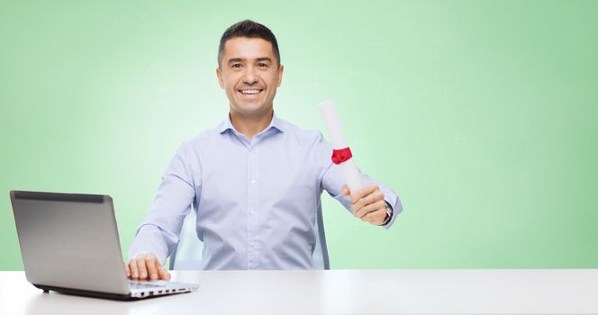 education, graduation, business, technology and people concept - smiling man with diploma and laptop computer sitting at table over green background