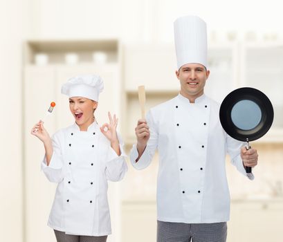 cooking, profession and people concept - happy male chef cook holding frying pan and spatula