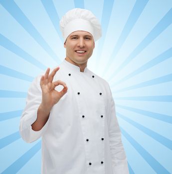 cooking, profession, gesture and people concept - happy male chef cook showing ok sign over blue burst rays background