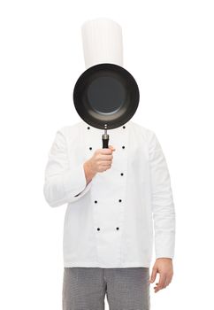 cooking, profession and people concept - male chef cook covering face or hiding behind frying pan