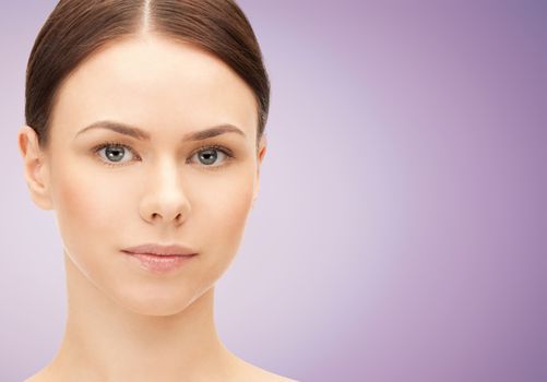 health, people and beauty concept - beautiful young woman face over violet background
