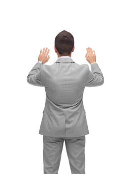 business, people, advertisement and office concept - businessman touching something imaginary from back