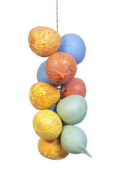 Colorful orange, yellow, green and blue painted coconut shells strung on rope hang as decoration isolated on white background