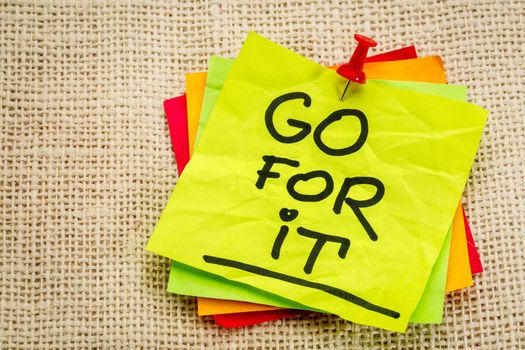 Go for it - motivational handwriting on a sticky note against burlap canvas