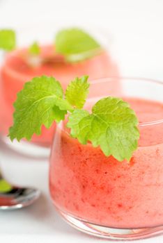 Smoothie drink with mint leafs on table, in high key