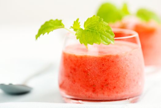 Smoothie drink with mint leafs on table, in high key