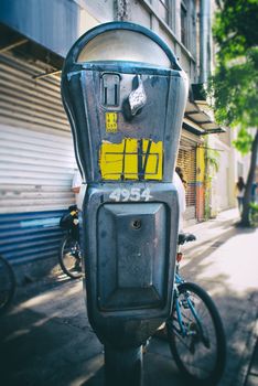 Photograph of an old metal parking meter on a sidewalk