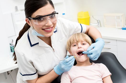 Dentist examining a little girl patient