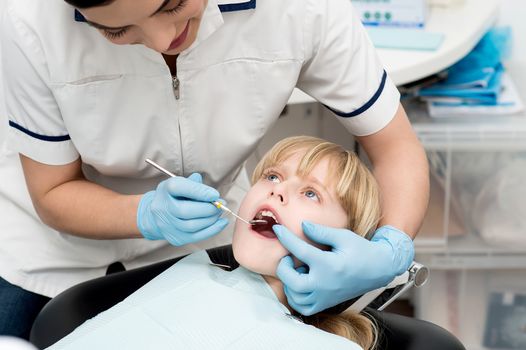 Cute kid undergoing dental treatment at clinic