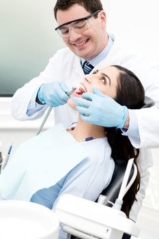 Male dentist treat female patient in dental office