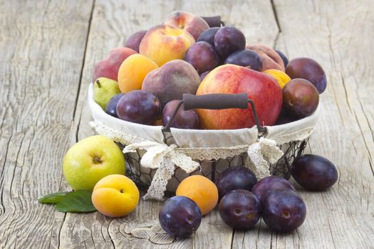 fresh fruits in a basket on wooden background