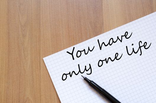 White blank notepad on office wooden table and text concept