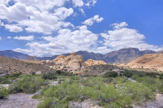 Beautiful scenic view of Aztec sandstone rock formations under cumulus clouds in Red Rock Canyon conservation area, Nevada