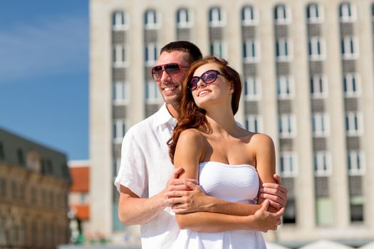 love, wedding, summer, dating and people concept - smiling couple wearing sunglasses hugging in city