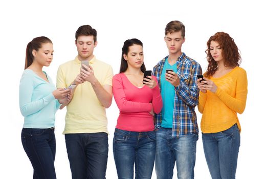 friendship, technology and people concept - group of serious teenagers with smartphones