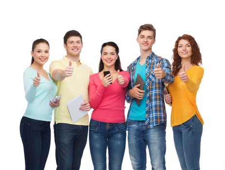 friendship, youth and people concept - group of smiling teenagers with smartphones and tablet pc computers showing thumbs up