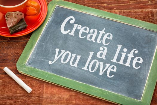 Create life you love motivational advice - text  on a slate blackboard with chalk and cup of tea
