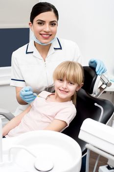 Dental assistant and little girl posing to camera